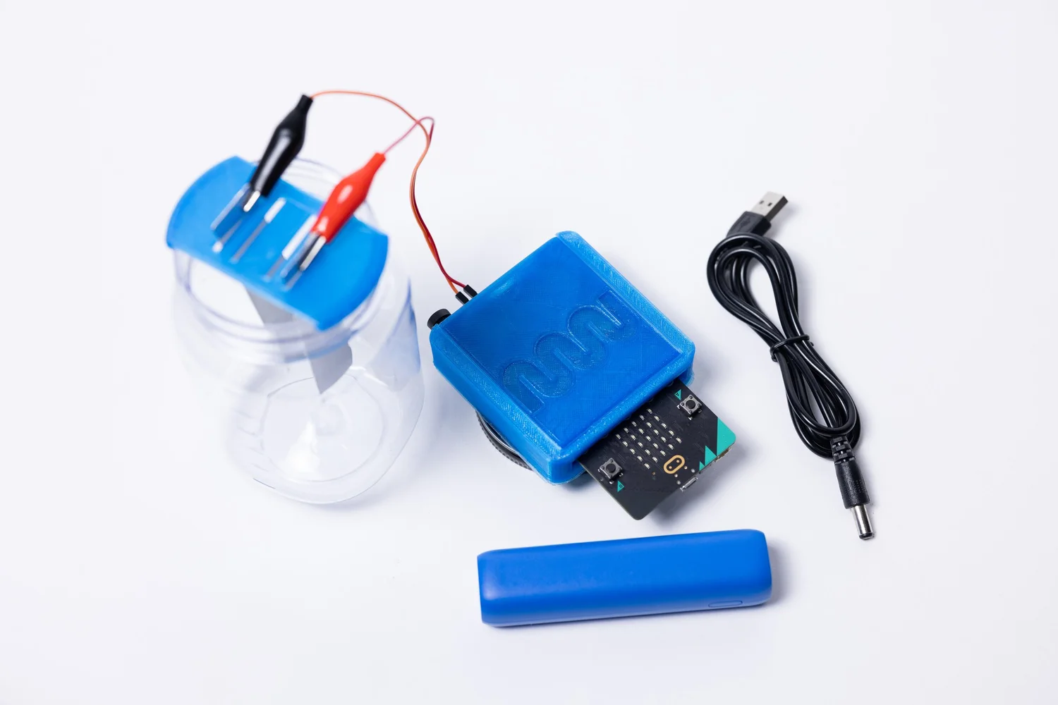 MakeWater coding kit with a blue enclosure, micro:bit, water container, and connecting cables